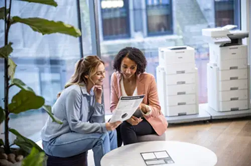 Two people discussing printer options in an office setting