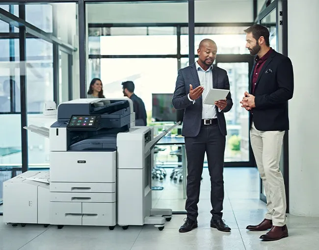 coworkers discussing next to a printer